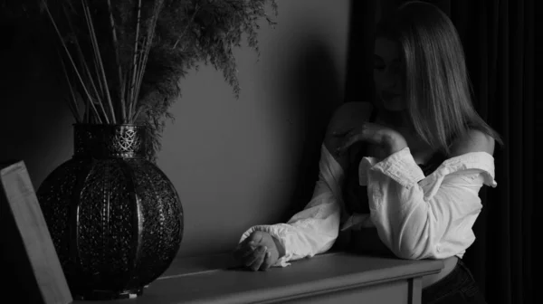 演播室里 穿着白衬衫 性感的年轻女子在钢琴前摆姿势的黑白照片 — 图库照片