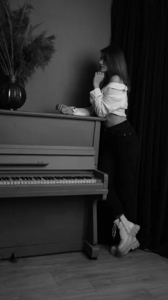 흰색으로 아름다운 관능적 스튜디오 안에서 피아노에 포즈를 취하는 셔츠를 — 스톡 사진