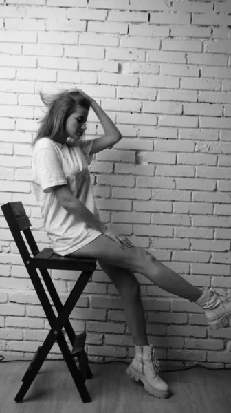 Stüdyoda Sandalyenin Yanında Uzun Saçlı Siyah Beyaz Bir Kadın Poz — Stok fotoğraf