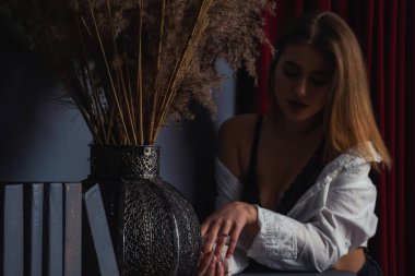 Stüdyoda piyanonun yanında poz veren uzun saçlı, güzel, şehvetli ve seksi bir kadının fotoğrafı..  