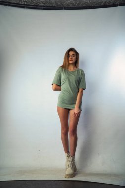 Stüdyoda beyaz bir duvara poz veren uzun saçlı seksi ve şehvetli genç bir kadının fotoğrafı..  