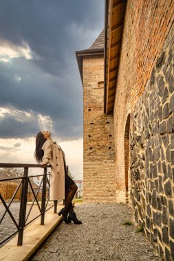 Antik mimarinin yanında kameraya poz veren güzel, genç, zarif bir kadın.