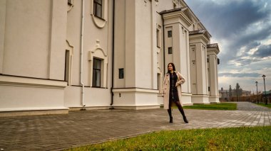 Antik mimarinin yanında kameraya poz veren güzel, genç, zarif bir kadın.