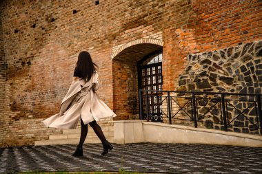 Antik mimarinin yanında kameraya poz veren güzel, genç, zarif bir kadın.