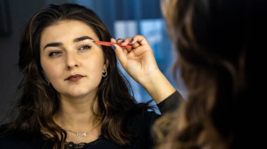 Güzel genç bir kadın aynanın karşısında hazırlanıyor, kişisel bakım konsepti. 