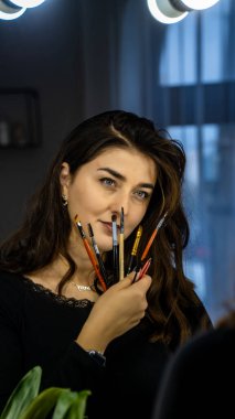 Güzel genç bir kadın aynanın karşısında hazırlanıyor, kişisel bakım konsepti. 