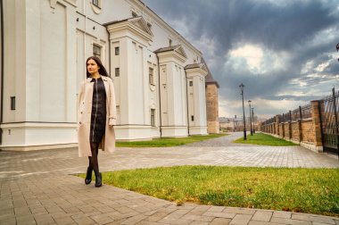 Antik mimarinin yanında kameraya poz veren güzel, genç, zarif bir kadın.