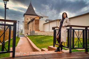 Antik mimarinin yanında kameraya poz veren güzel, genç, zarif bir kadın.