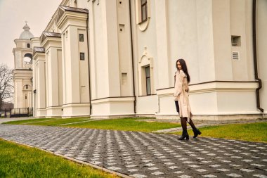 Antik mimarinin yanında kameraya poz veren güzel, genç, zarif bir kadın.