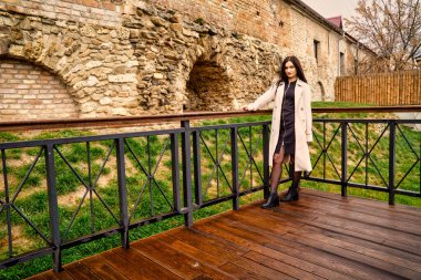 Antik mimarinin yanında kameraya poz veren güzel, genç, zarif bir kadın.