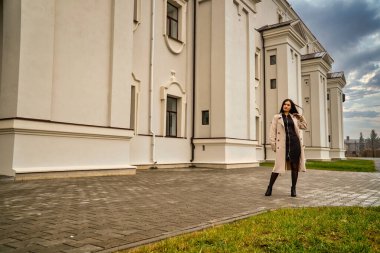 Antik mimarinin yanında kameraya poz veren güzel, genç, zarif bir kadın.