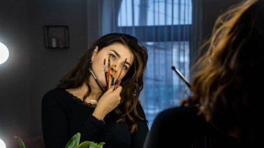 Güzel genç bir kadın aynanın karşısında hazırlanıyor, kişisel bakım konsepti. 