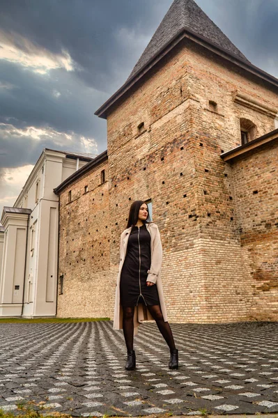 Antik mimarinin yanında kameraya poz veren güzel, genç, zarif bir kadın.