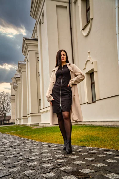 Antik mimarinin yanında kameraya poz veren güzel, genç, zarif bir kadın.