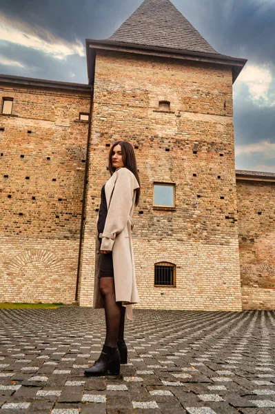 Antik mimarinin yanında kameraya poz veren güzel, genç, zarif bir kadın.