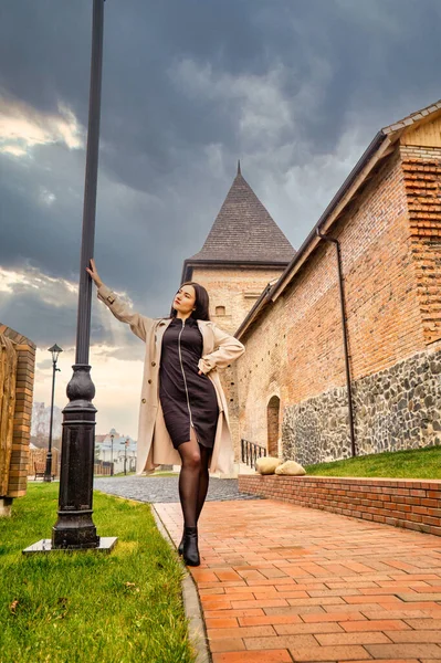 Antik mimarinin yanında kameraya poz veren güzel, genç, zarif bir kadın.