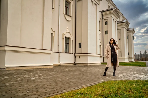 Antik mimarinin yanında kameraya poz veren güzel, genç, zarif bir kadın.