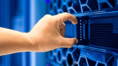 Bilgisayar mühendisleri modern ekipmanlarla dolu bir veri tabanında ekipmanları tamir ediyorlar..