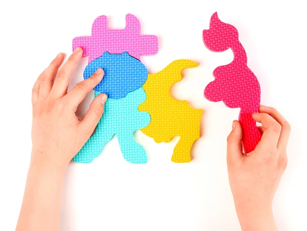 Hand en veelkleurige schuim puzzel — Stockfoto