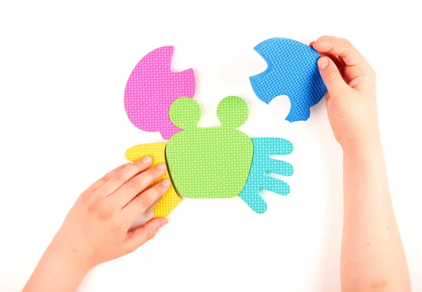 Hand and multicolored foam puzzle — Stock Photo, Image