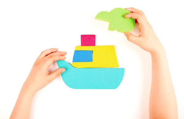 Hand and multicolored foam puzzle — Stock Photo, Image