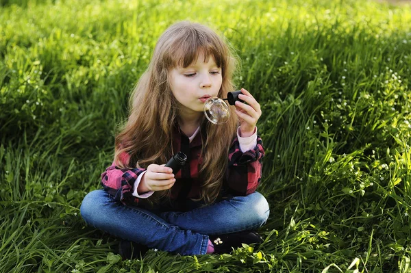 Menina soprando bolhas de sabão no parque — Fotografia de Stock