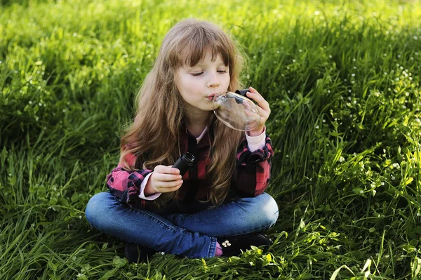 Menina soprando bolhas de sabão no parque — Fotografia de Stock
