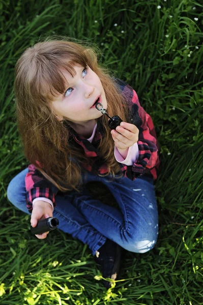 Little girl blowing soap bubbles in the park — Stock Photo, Image