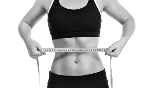 Joven mujer fitness midiendo su cintura — Foto de Stock
