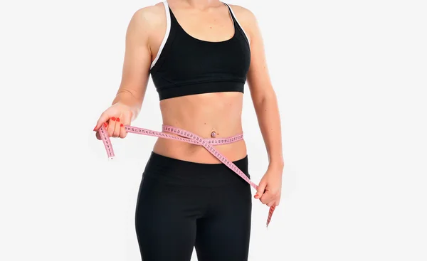 Jonge fitness vrouw haar taille meten — Stockfoto