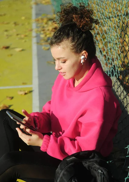 Curly Hair Woman Pink Sportswear Headphones Mobile Phone Playground — Stock Photo, Image