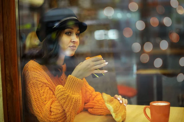오렌지 스웨터를 크로이스 여자와 뒤에서 커피를 마시고 — 스톡 사진