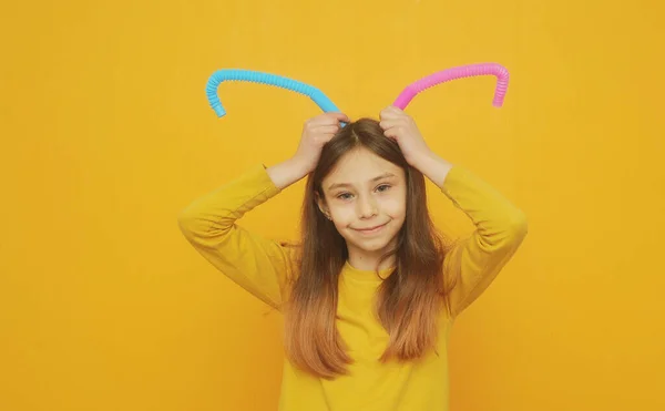 Menina Inteligente Pouco Roupas Amarelas Brinca Com Tubo Pop Brinquedo — Fotografia de Stock