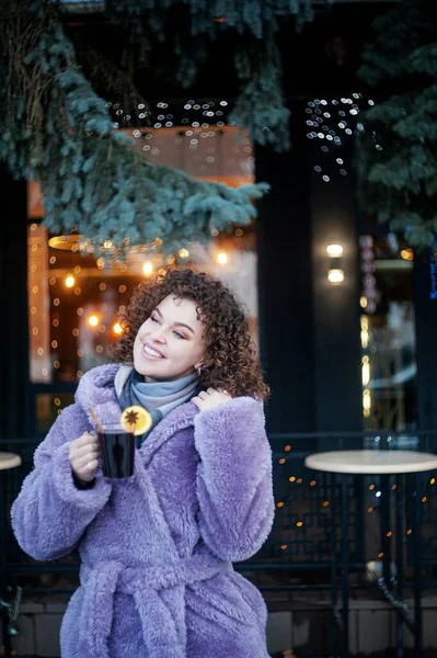 Smiling Curly Haired Woman Trendy Violet Coat Drinks Mulled Wine — Zdjęcie stockowe