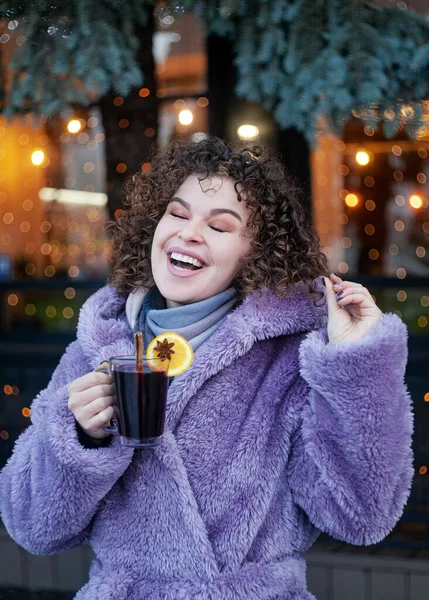 Smiling Curly Haired Woman Trendy Violet Coat Drinks Mulled Wine — Stock Fotó