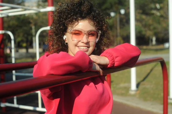 Cute Curly Hair Woman Pink Sportswear Headphones Playground — Stockfoto