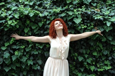 Çiçek açan bahçedeki güzel kızıl saçlı kadın, bahar geliyor konsept.