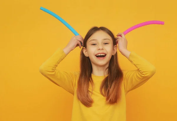 Smart Girl Yellow Clothes Plays Trendy Toy Pop Tube — 图库照片