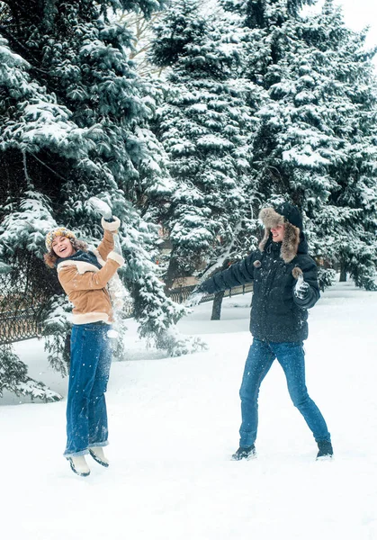 Karla oynayan kadın ve erkek. Mutlu çift dışarıda eğleniyor..