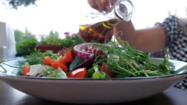 cropped video of young woman with vegetable salad and tomato sauce