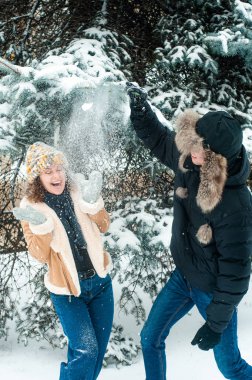Karla oynayan kadın ve erkek. Mutlu çift dışarıda eğleniyor..