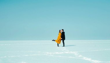 Mutlu yürüyen çift. Karlı buzda yürüyen bir kadınla bir adama aşık oldum. Kış tatili kavramı. Sevgililer günün kutlu olsun..