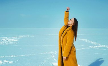 Sarı ceketli güzel bir kadın, karlı buzda yürüyor.. 