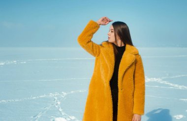 Sarı ceketli güzel bir kadın, karlı buzda yürüyor.. 