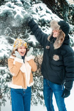 Karla oynayan kadın ve erkek. Mutlu çift dışarıda eğleniyor..