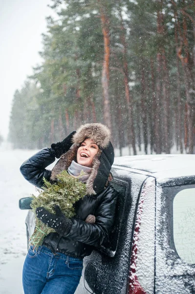 소나무를 아름다운 미소짓는 여인은 야외에서 재미를 눈덮인 — 스톡 사진