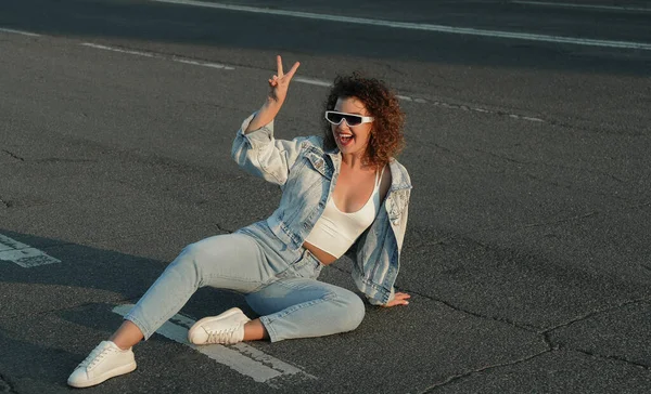 Gülümseyen kadın yolda oturuyor, özgürlük konsepti.
