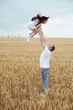 Baba ve kızı sahada eğleniyor. Mutlu aile kavramı. Babam kızını gökyüzüne fırlattı. 