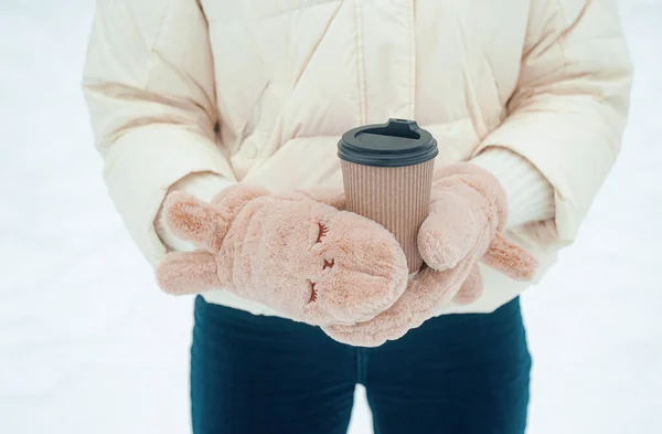 밖에서 마시는 뜨거운 음료를 마시는 여자는 눈내리는 날씨에 공원에서 재미를 — 스톡 사진