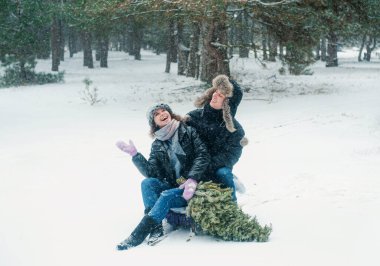 Mutlu çift karla eğleniyor. Kadın ve erkek kış ormanlarında yürüyor. 